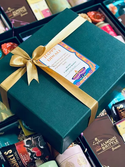 We specialize in creating premium corporate gifts that make a statement. This Diwali hamper, designed for a corporate client, features a sophisticated green and gold theme, filled with gourmet treats and festive essentials, ready for bulk delivery.