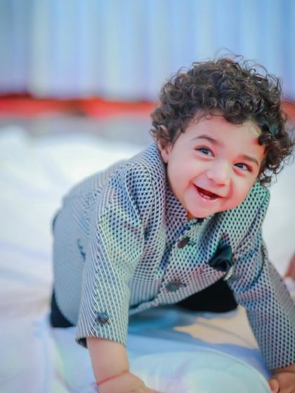 That heart-melting smile says it all. This little one is comfortable and happy in his custom-patterned occasion wear jacket, proving that formal wear can be fun.