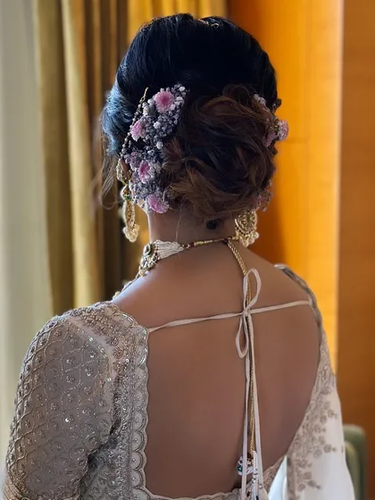 A textured bridal bun with delicate purple flowers. This style is perfect for brides who want a touch of color in their hairstyle without it being overwhelming.