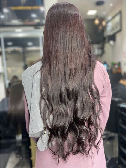 Long, dark hair styled with soft, elegant waves at the ends for a classic and polished look.