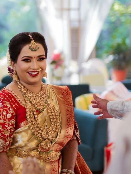 A candid moment of happiness. This bride's joyful smile says it all. Her makeup was kept classic and radiant to match her beautiful red and gold silk saree for her South Indian wedding.