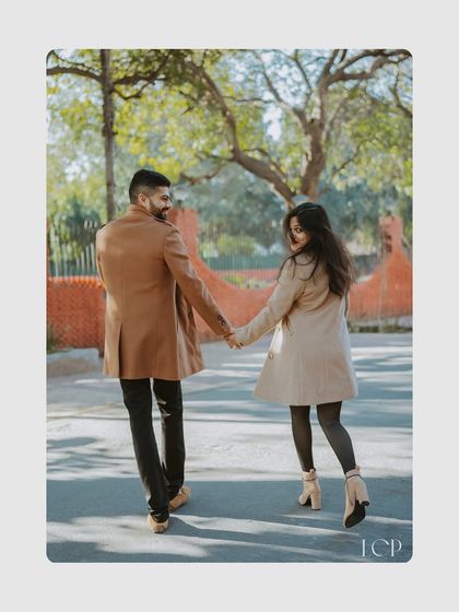 A candid shot of a couple walking hand-in-hand, sharing a joyful glance back. We capture the natural, unposed interactions that define your connection.