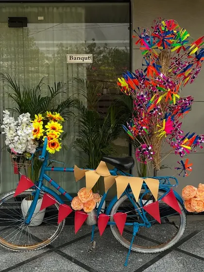 A quirky and colorful decor prop for an entrance or photo corner, featuring a decorated bicycle with pinwheels and flowers.