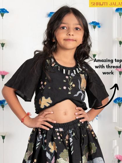 I believe the magic is in the details. This black lehenga set features a crop top with delicate thread work and mirror accents around the neckline, paired with a skirt that has a playful wildlife embroidery.