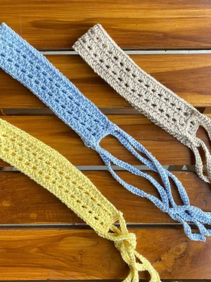 Our tie-up headbands are available in many colors. This photo shows a few options in yellow, blue, and beige, all handmade by us.