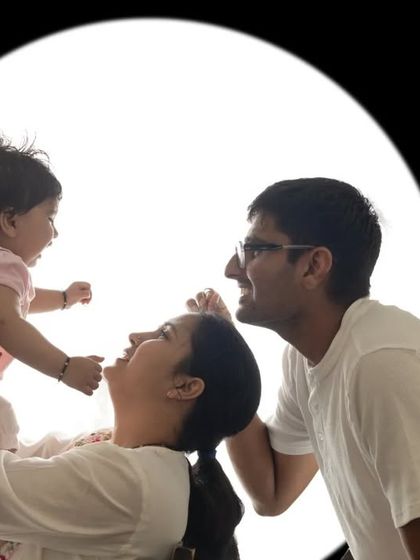 A playful family interaction captured with creative backlighting. The circular frame and bright light create a modern and artistic feel.
