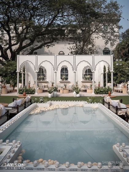 The poolside lounge view, emphasizing the tranquility of the water feature and how it complements the elegant white decor of the wedding.