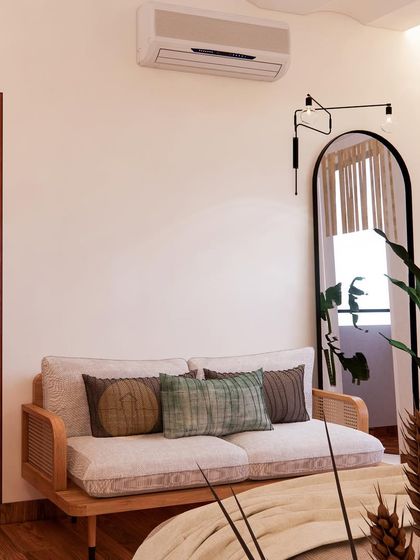 A corner of a minimalist bedroom with a cane settee and a large arched mirror, creating a simple yet elegant spot for relaxing.
