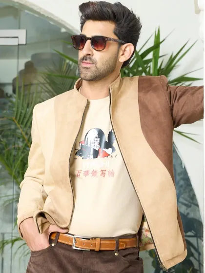 Suede sophistication with a bold twist. This two-toned tan and brown jacket brings earthy tones to life with its smooth texture and standout asymmetrical paneling.