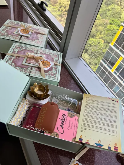 Another view of the personalized Diwali hamper, showing the custom letter and branded items against a city backdrop, perfect for a corporate setting.