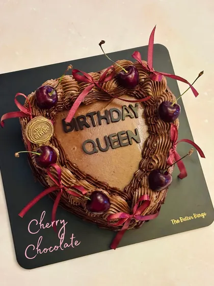 An overhead view of our heart-shaped Cherry Chocolate cake. I love adding personal touches like the "Birthday Queen" message to make your celebration feel unique.