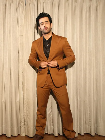 This full-length view of Satyajeet Dubey's brown suit highlights the perfect fit and flare of the trousers, designed to complement the structured jacket. It's a complete look rooted in traditional craftsmanship.