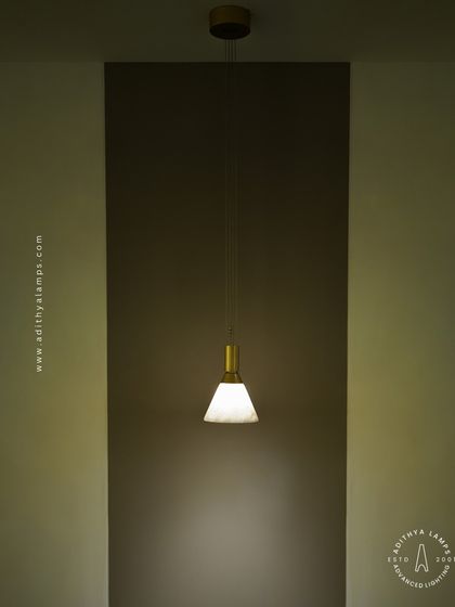This single pendant light with a marble-finish shade and brass fitting is a study in minimalist elegance. It is perfect for providing focused task lighting or creating a soft ambient glow in a quiet corner.