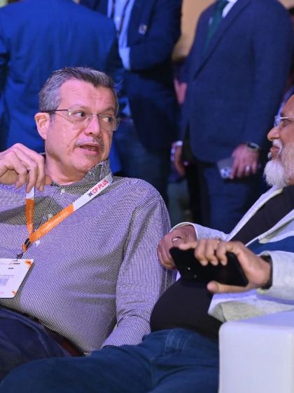 Two senior professionals share a conversation during a break, underscoring the expo's importance as a meeting point for industry veterans.