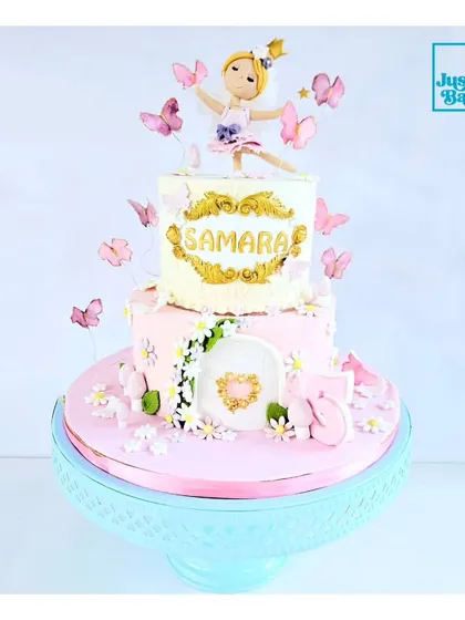 A garden party fit for a princess. This two-tiered cake features a delicate ballerina princess topper, surrounded by edible butterflies and tiny flowers. The personalized name plaque adds a special touch to this enchanting design.