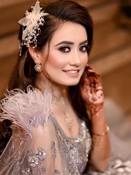 A close-up of this gorgeous engagement look. The feathered shoulder detail and hair accessory add a touch of modern glamour.