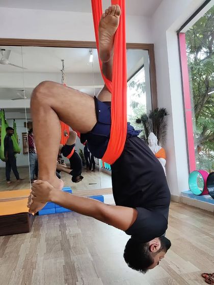 An inverted pose in the aerial hammock, allowing the spine to lengthen and release tension.