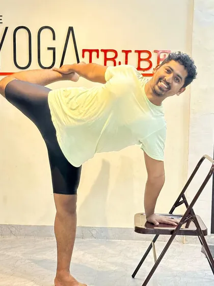 Demonstrating Natarajasana (Dancer's Pose) with the help of a chair. The chair provides balance and support, allowing you to focus on the backbend and opening the shoulder.