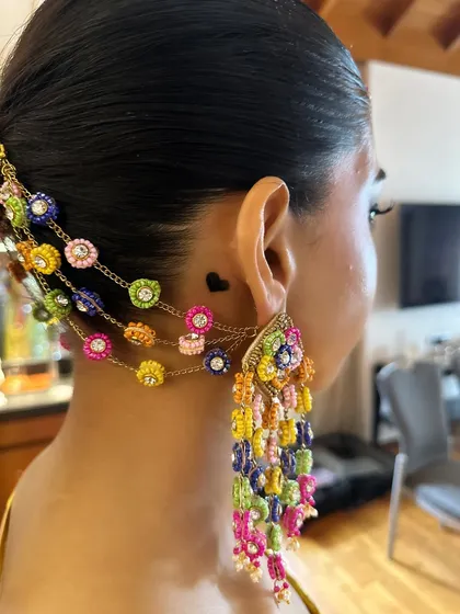 A detailed close-up of the colorful accessories woven into Aish's Haldi braid. These beautiful handcrafted pieces add a unique and personal touch to the traditional hairstyle.