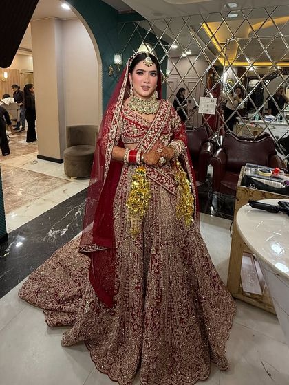 A full-length view of the bride in our salon. The grand lehenga with its long trail is perfectly complemented by the elegant makeup and hair.