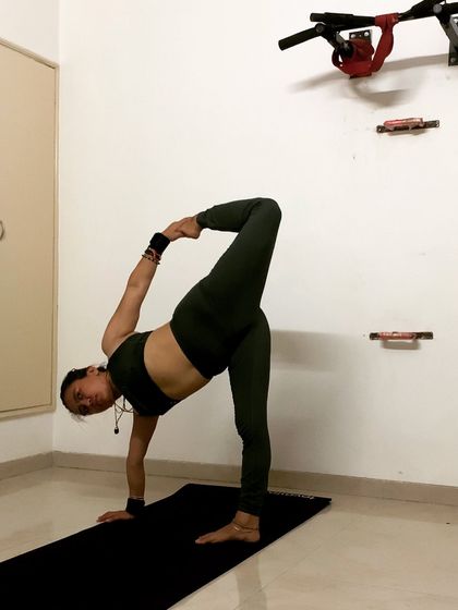 A standing stretch, Parivrtta Ardha Chandrasana (revolved half-moon pose). This pose challenges balance while providing a deep stretch for the hamstrings and spine.