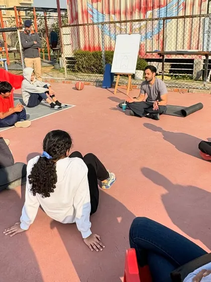 Players seated on the court, engaged in a discussion during a workshop. We create an open environment for learning and questions.