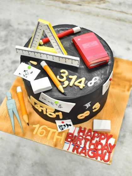 An overhead view of the math-themed cake, showing the arrangement of the edible pencils, rulers, and formulas.