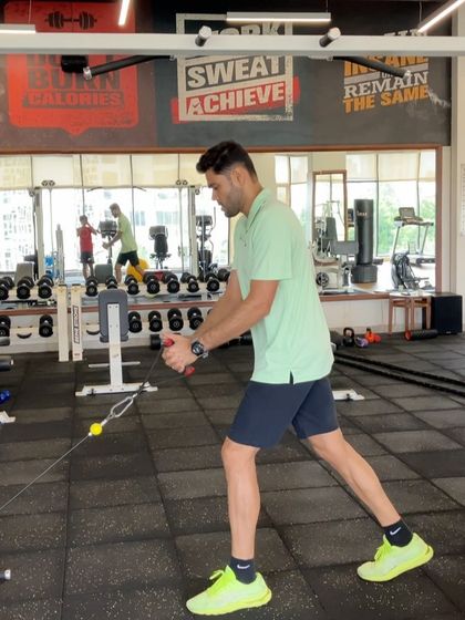 A standing cable rotation in a different gym setting, showing the versatility and importance of this fundamental rotational strength exercise.