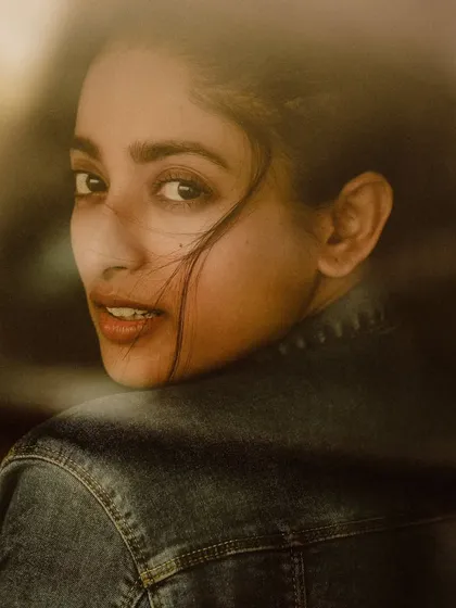A soft, hazy portrait of a model looking over her shoulder. The dreamy focus and warm tones create an intimate and slightly mysterious mood.