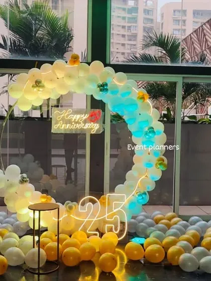 For a grand 25th anniversary celebration, I created this elegant circular balloon arch in a corporate lobby. The design combines white and gold balloons with dynamic lighting, a "Happy Anniversary" neon sign, and large marquee numbers to create a stunning photo opportunity.