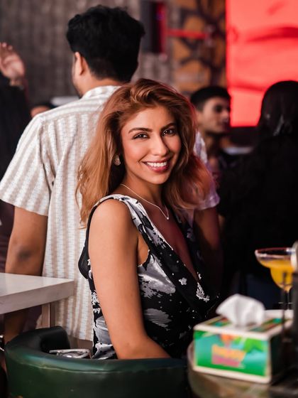 A guest enjoying the vibe from her table. You can have a great time whether you're on the dance floor or chilling with a drink.
