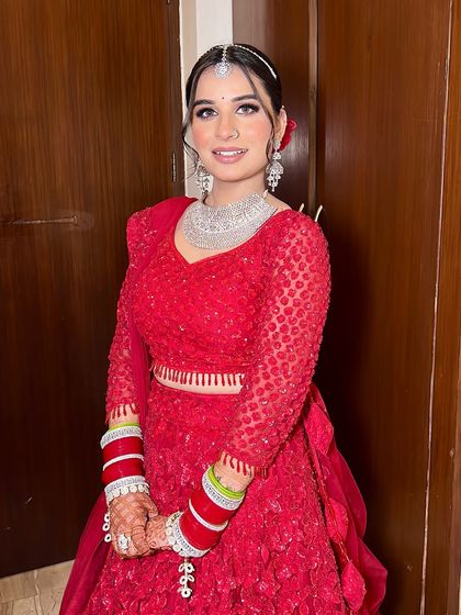 The full look for Anjali, showcasing her stunning red lehenga and diamond jewelry. She looks comfortable, confident, and absolutely beautiful.