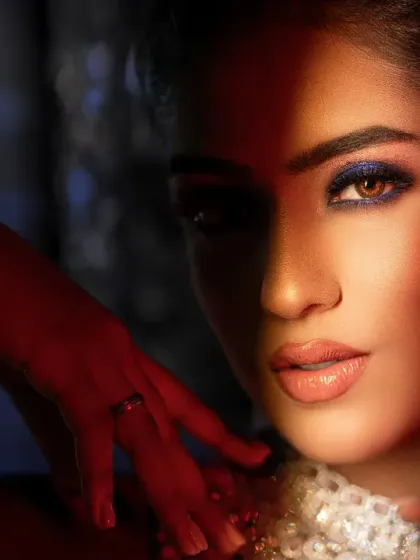 A close-up bridal portrait with dramatic red lighting on one side of her face. This technique creates a bold, high-fashion look.