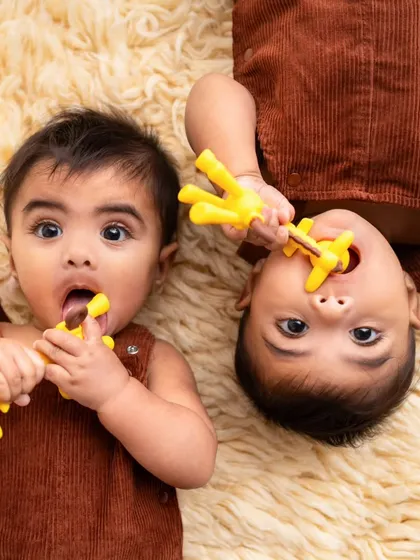 These twin boys are exploring their teethers during their 6-month sitter session. It's a fun way to capture their developmental milestones.