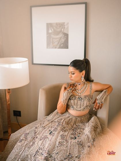 Another beautiful portrait, with the bride looking down, showcasing her eye makeup and the details of her outfit.