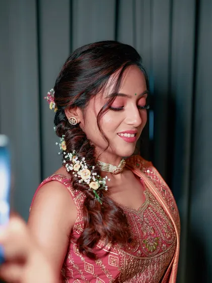 A close-up of the Haldi makeup, featuring soft pink eyeshadow and a beautiful floral braid.