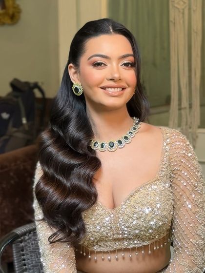 A happy client showing off her glamorous waves. This style is designed to be long lasting, so she can enjoy her event without worrying about her hair.