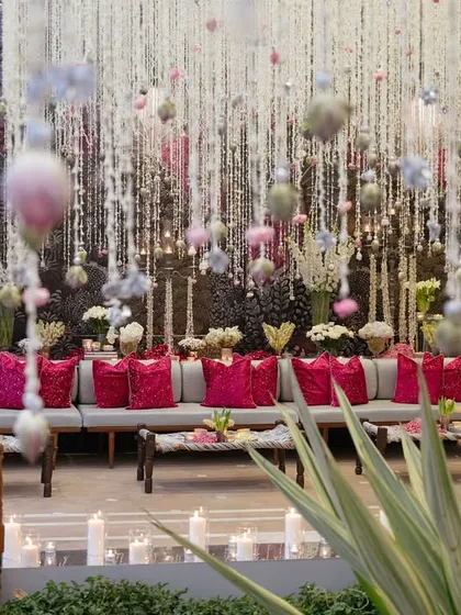 Thousands of delicate flower strings create a breathtaking canopy over a lounge area. This detail-intensive decor element transforms a space, creating a sense of wonder and a perfect backdrop for photos.