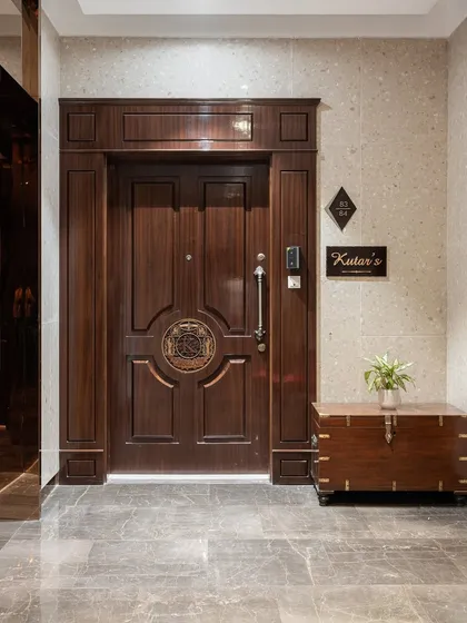The entrance sets the tone for the entire home. We designed this grand wooden door with intricate paneling and a custom emblem to create a timeless and stately first impression, reflecting the heritage and elegance of the family within.