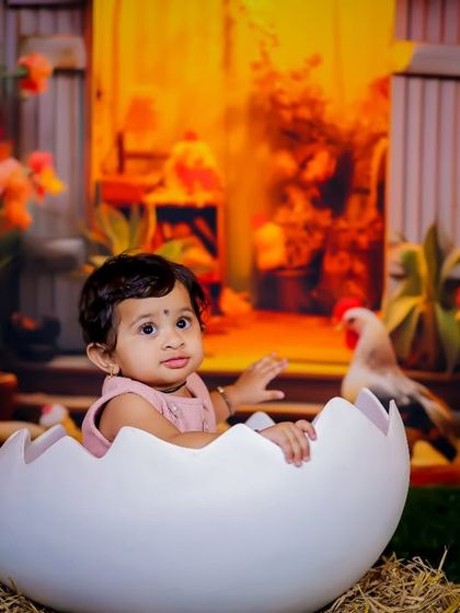 "Hatching" a plan for fun in our farmyard set. This setup features a large eggshell prop, hay, and a backdrop of a barn with chickens, creating a complete and playful rural scene.