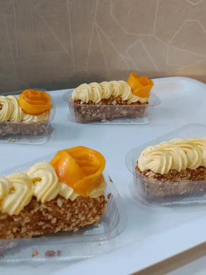A closer look at my 'Mangomisuwich' treats, all lined up and ready. You can see the layers of homemade cookie, cream, and fresh mango rosette on top.