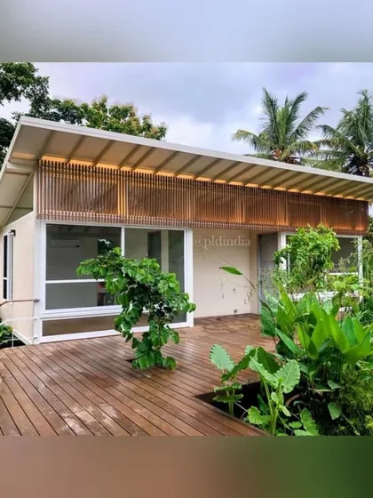 A wooden deck provides a space for lounging right at the edge of the pond. The surrounding plants, including large-leafed colocasia, create a sense of being enveloped by a tropical jungle.