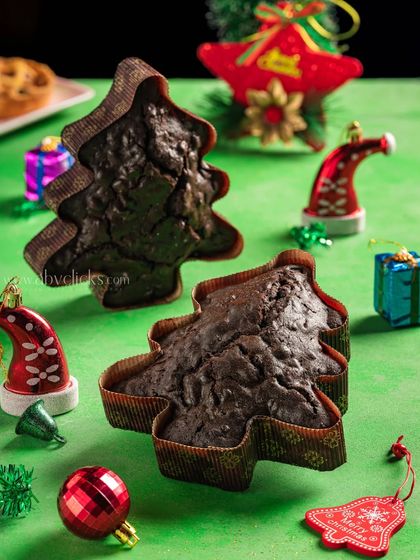 A festive shot of tree-shaped chocolate cakes surrounded by Christmas decorations, ideal for a holiday catalog.