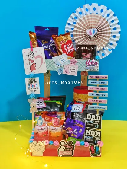 My customized baby shower hamper for the parents-to-be! It's a two-tier stand filled with snacks and adorable baby-themed decorations.