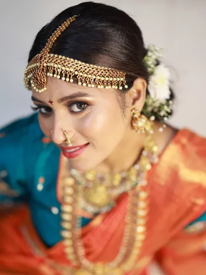 A high-angle shot that gives a different perspective on the traditional bridal look. It focuses on the model's expressive eyes and the beautiful 'matha patti' headpiece.