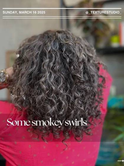 These are what I call smokey swirls. We added cool-toned highlights to these curls to create a unique, dimensional look that complements the natural grey blending.