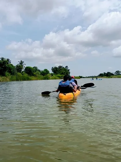 A serene kayaking scene, showing two people paddling on the calm waters of a reservoir.