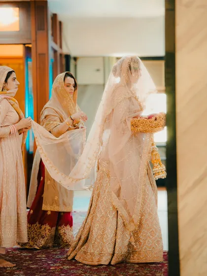 The bridal entry is a key moment. Here, we capture the bride's grand entrance into the Gurudwara, with her bridesmaids holding the veil.