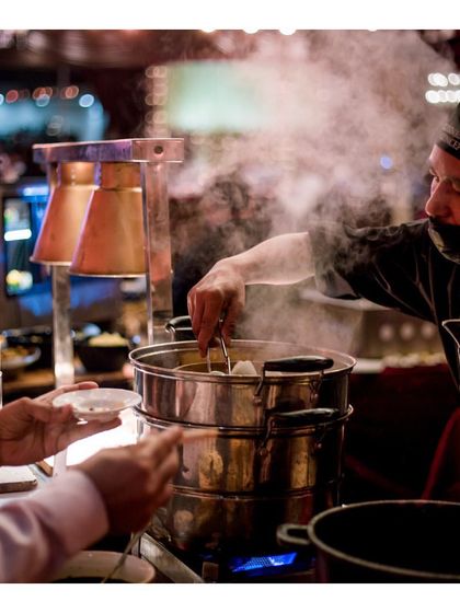 A guest receives a steaming hot dim sum straight from a traditional bamboo steamer. Our live dim sum stations offer a variety of delicate, flavourful dumplings, providing an authentic taste of Asia.