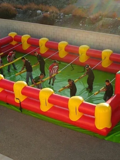 Bring team competition to your event with our Inflatable Human Foosball arena. Players are strapped to poles and must work together to score, creating a hilarious and engaging game for teens and adults.